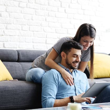 A couple at home going through paperwork on a laptop