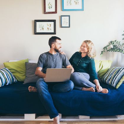 A couple on the sofa checking figures on a laptop