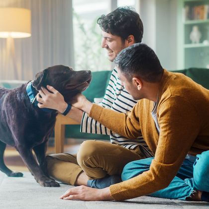 A family sitting on the floor with their dog
